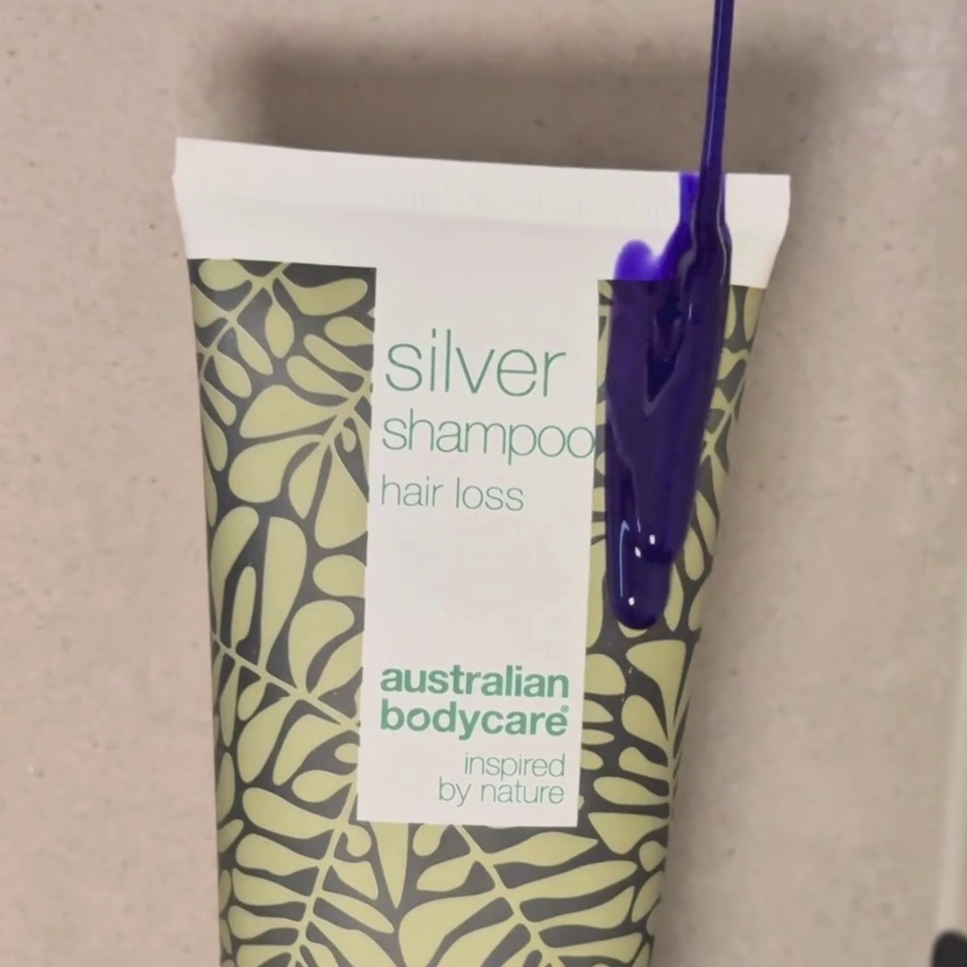 Video showing our Hair Loss Silver Shampoo with a silver-purple tint being applied to wet hair in the shower.