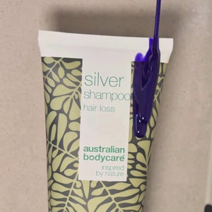 Video showing our Hair Loss Silver Shampoo with a silver-purple tint being applied to wet hair in the shower.