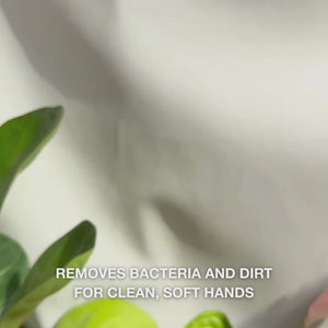 Close‑up of a pair of hands pumping clear, foamy light‑blue hand wash enriched with Tea Tree Oil into a palm, then gently lathering over the backs, palms, and between fingers—showcasing the smooth, cleansing foam that removes bacteria and dirt while softening and hydrating the skin.